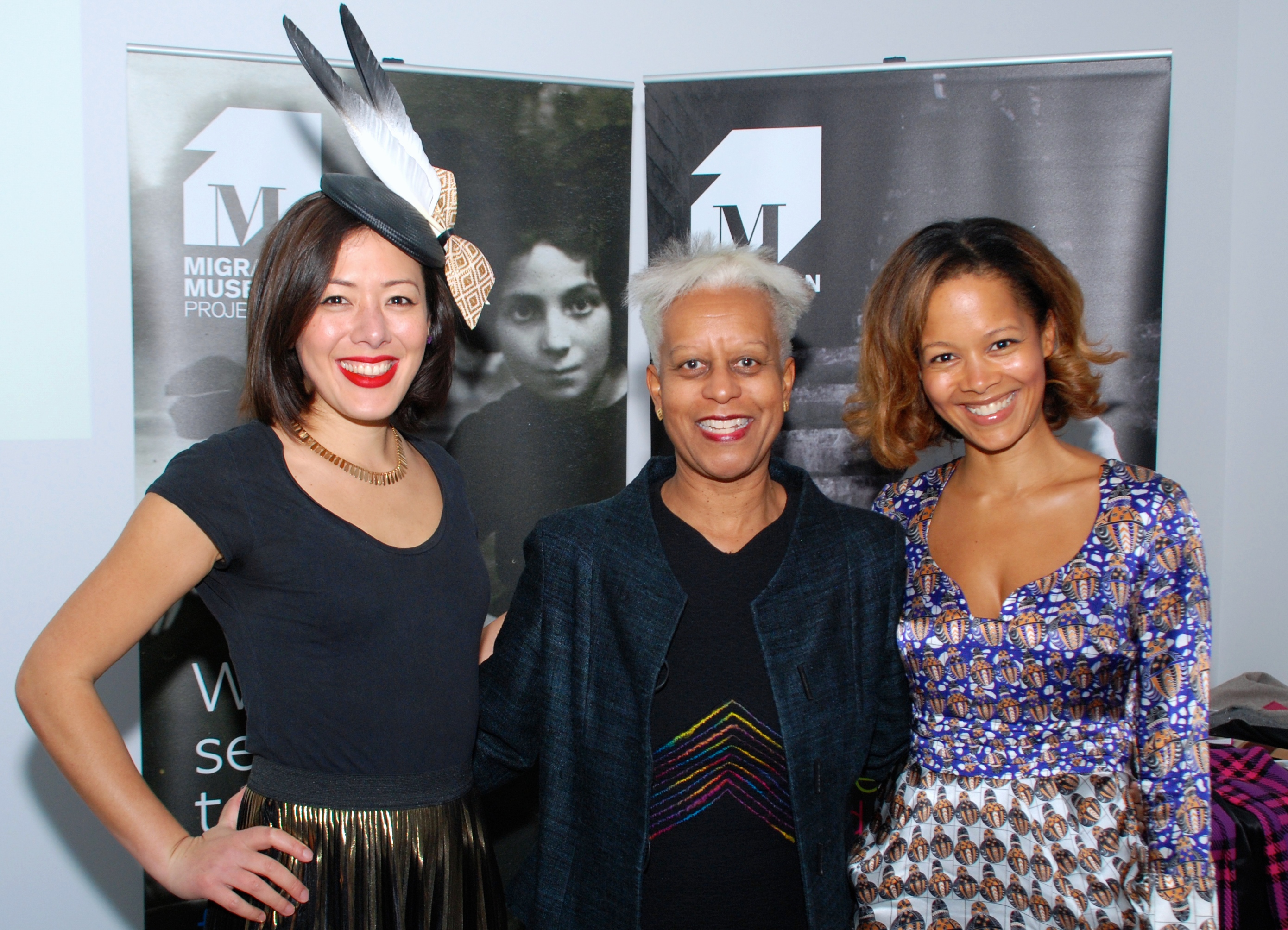 Photograph of Migration & Fashion event speakers in front of Migration Museum Project banners